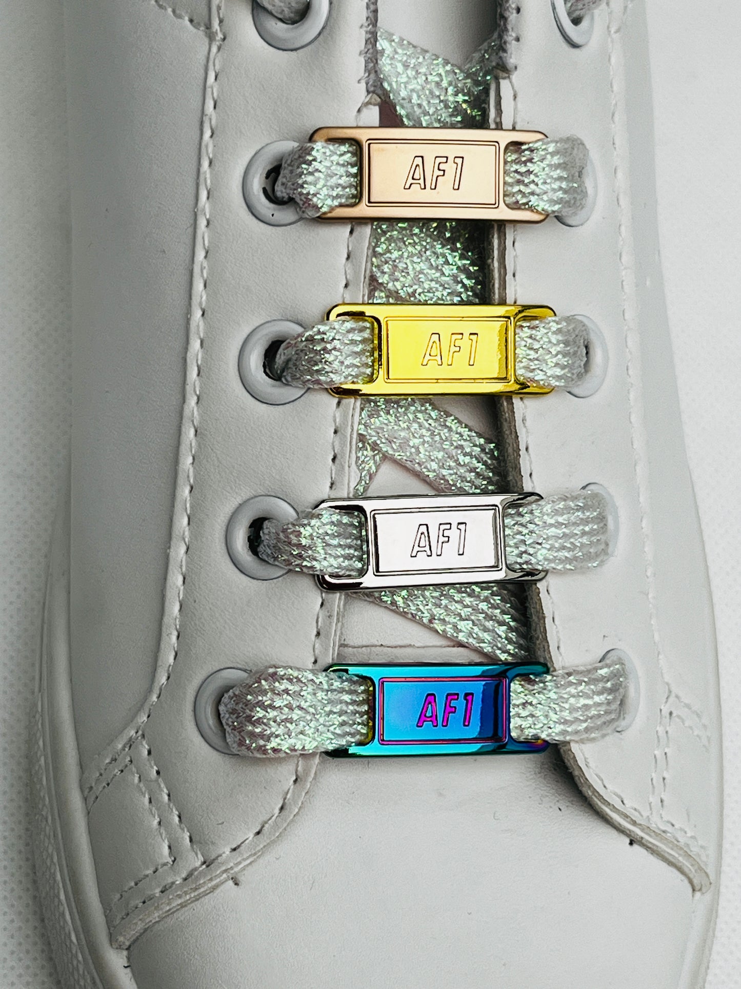 une basket blanche avec des boucles de lacets or argent rose gold et multicolor
