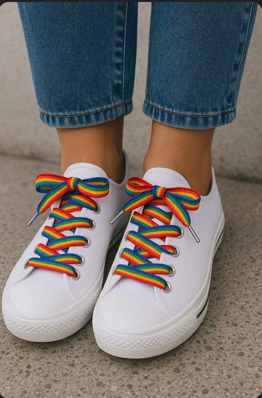 une paire de converses blanches avec des lacets arc en ciel