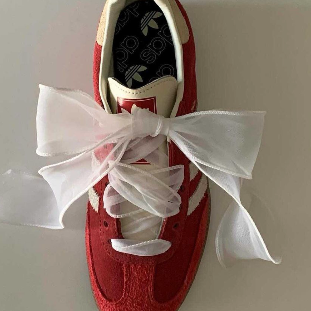 une basket rouge avec des lacets en organza blancs