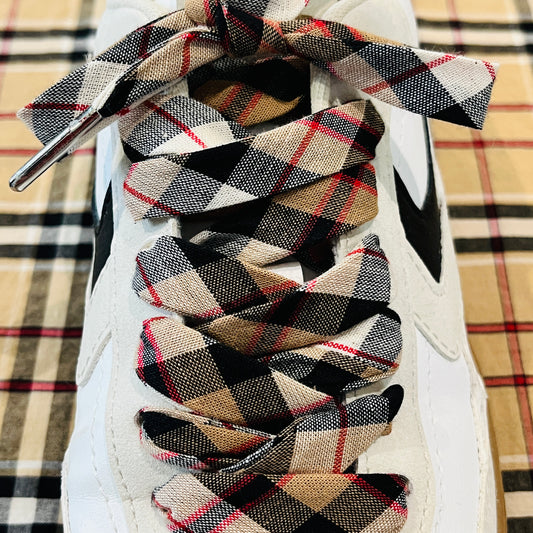 lacets tartan à carreaux beiges et rouges avec des aglets argentés.