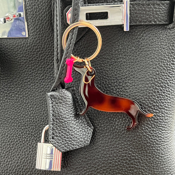 mini porte clef teckel en acrylique avec un os rose fluo et une boucle dorée