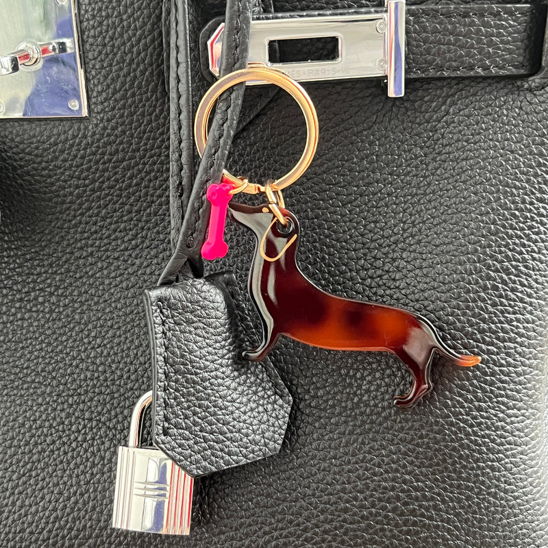 mini porte clef teckel en acrylique avec un os rose fluo et une boucle dorée