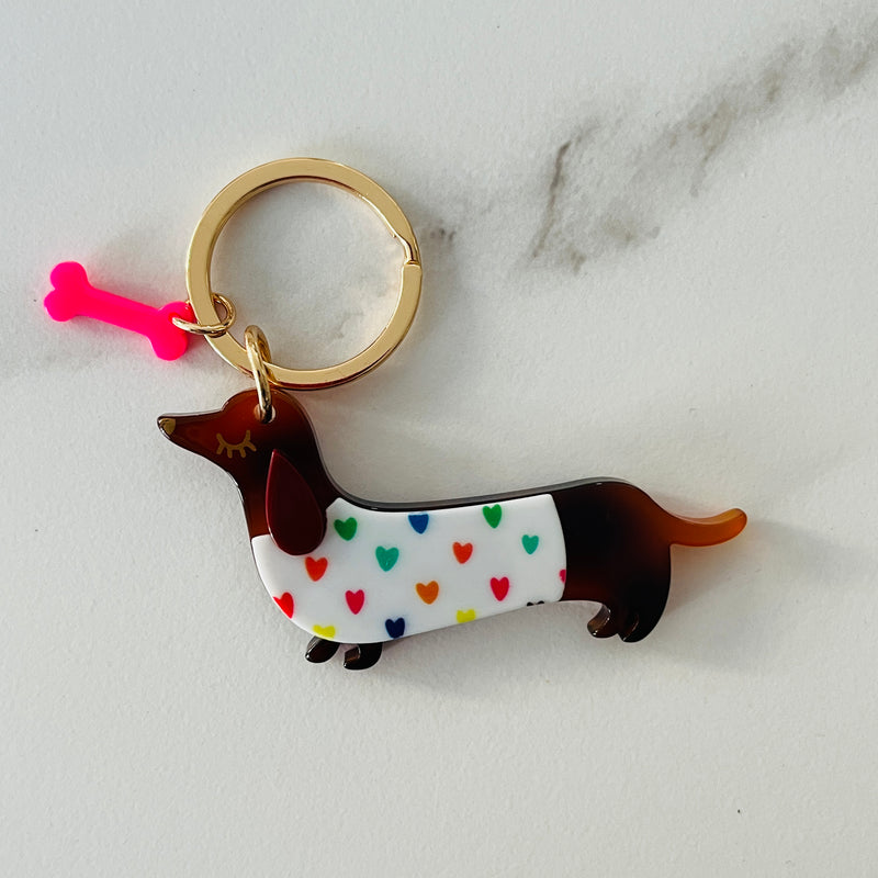 Petit porte-clé chien teckel avec motif cœurs multicolor et os rose fluo